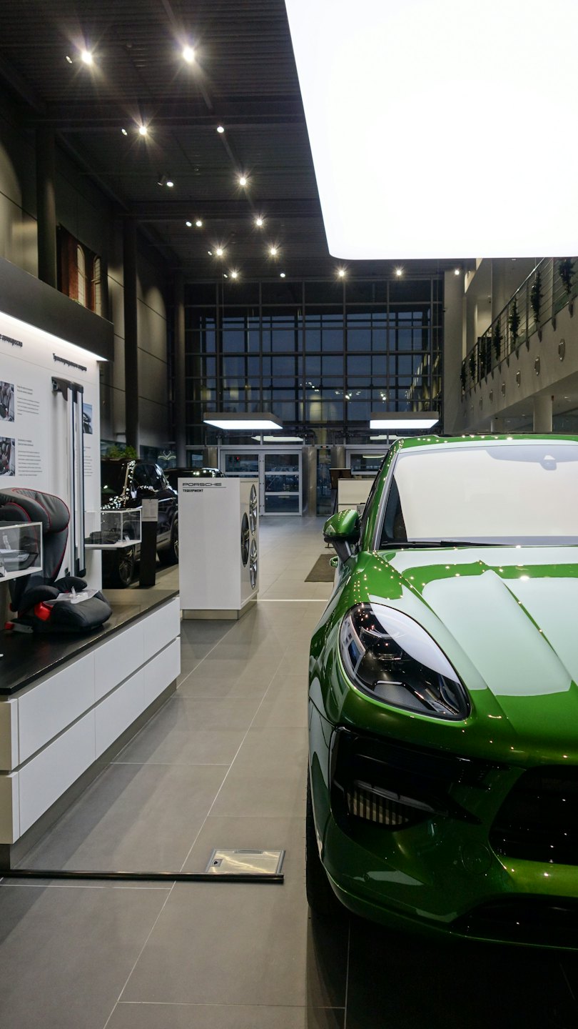 Bright green luxury SUV parked inside a modern car dealership.